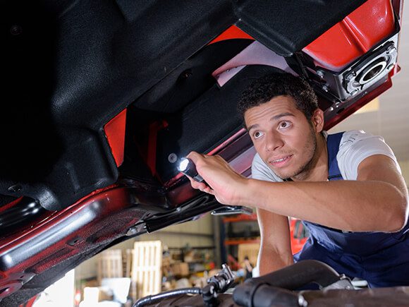 Truck Technician checking truck engine.