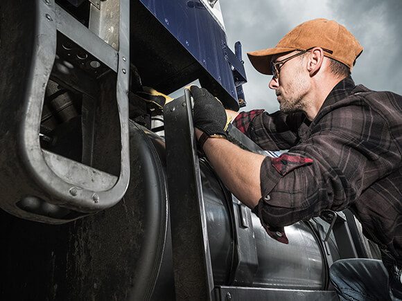 Truck Technician checking dump track fuel tank.