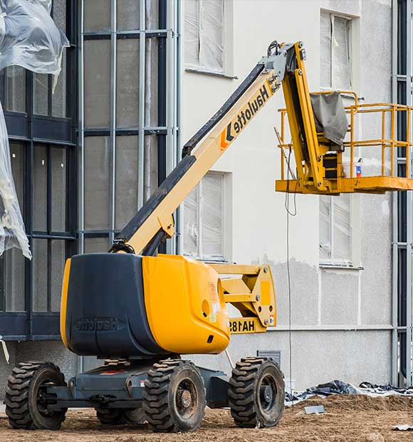 A Man lift equipment on a construction site.
