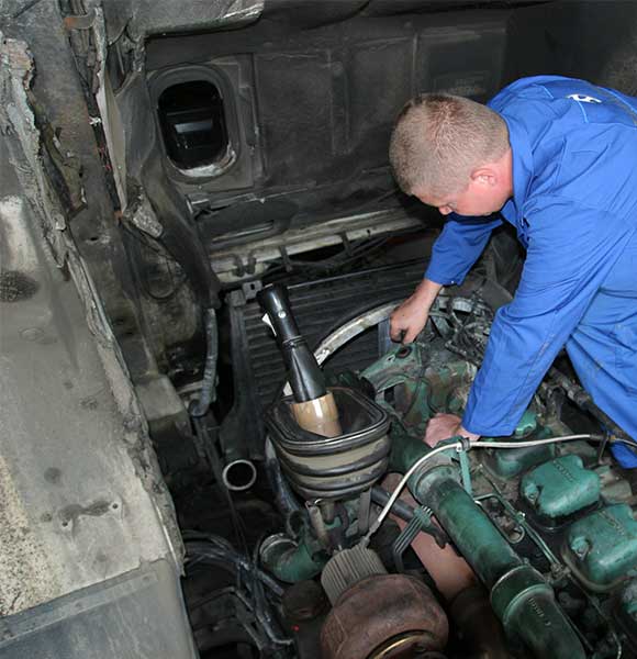 Truck technician repairing an old engine.