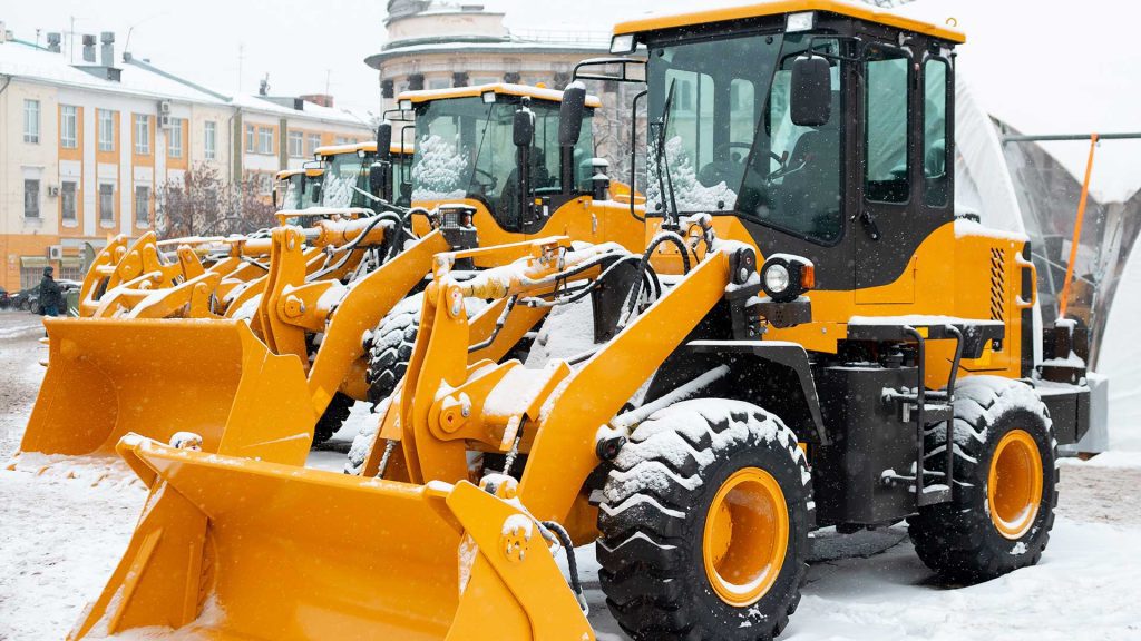Wheel loaders covered with snow.
