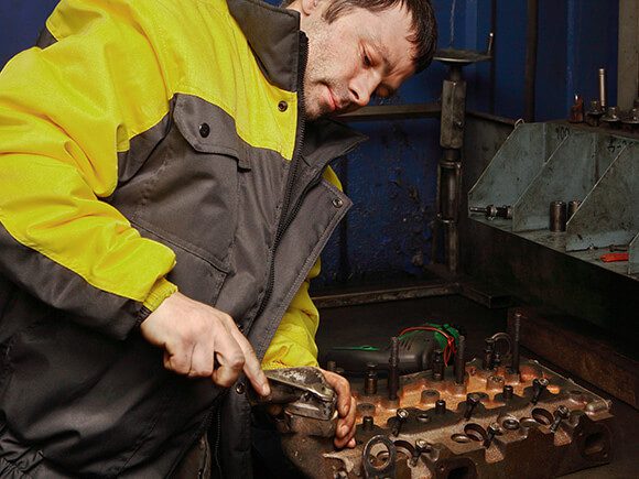 Truck Technician working on forklift mast chain maintenance.